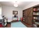 Well-lit home office with hardwood floors, custom shelving, and comfortable workspace at 10217 Falling Leaf Dr, Concord, NC 28027