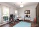 Bright home office with hardwood floors, large windows, custom storage, and comfortable furnishings at 10217 Falling Leaf Dr, Concord, NC 28027
