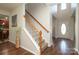 Elegant staircase featuring hardwood floors, white banisters, and a stylish entrance at 10217 Falling Leaf Dr, Concord, NC 28027