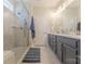 Bathroom features a double vanity, sleek gray cabinets, and a glass enclosed shower at 1022 Curling Creek Dr, Indian Trail, NC 28079