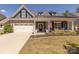 Charming home featuring stone accents, a covered porch and well-manicured front lawn at 1022 Curling Creek Dr, Indian Trail, NC 28079
