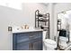 Modern bathroom with a blue vanity, marble countertop, and a black and white patterned floor at 1105 S Point Rd, Belmont, NC 28012
