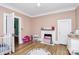 Bright bedroom with a fireplace, toys, and hardwood floors at 1105 S Point Rd, Belmont, NC 28012