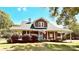 Charming brick home with a welcoming front porch, American flag, and well-maintained landscaping at 1105 S Point Rd, Belmont, NC 28012