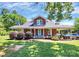 Inviting two-story brick home with a large front yard and covered porch featuring a car port on the side at 1105 S Point Rd, Belmont, NC 28012