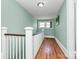 Hallway with wood floors, white railing, and fresh paint at 1105 S Point Rd, Belmont, NC 28012
