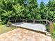 Charming backyard features a wooden deck with black railing and a tile patio, surrounded by lush trees at 1124 Hunter St, Statesville, NC 28677