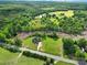 Picturesque aerial view of a private home surrounded by trees and open fields at 1166 Rocky River Rd, Lancaster, SC 29720