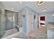 Luxurious primary bathroom with a tiled shower, marble countertops, and elegant lighting fixtures at 1166 Rocky River Rd, Lancaster, SC 29720