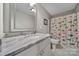 Stylish bathroom with a marble countertop and a colorful shower curtain at 1166 Rocky River Rd, Lancaster, SC 29720