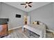 Neutral-toned bedroom with a ceiling fan, television, and a bed covered with a neutral patterned comforter and decorative pillows at 1166 Rocky River Rd, Lancaster, SC 29720