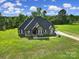 Inviting home exterior featuring stone and siding details, surrounded by a green lawn at 1166 Rocky River Rd, Lancaster, SC 29720