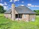 Back exterior of home with covered patio and stone fireplace at 1166 Rocky River Rd, Lancaster, SC 29720