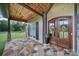 Inviting front porch with stone flooring, decorative columns, and a welcoming entrance at 1166 Rocky River Rd, Lancaster, SC 29720