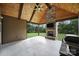 Covered outdoor patio showcases a stone fireplace and beautiful wood ceilings at 1166 Rocky River Rd, Lancaster, SC 29720