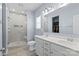 Bright bathroom featuring a double sink vanity, tiled shower with glass door, and large mirror at 122 Dyssa Loop, Statesville, NC 28625