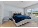 Bright main bedroom with plush bedding and natural light from two large windows at 122 Dyssa Loop, Statesville, NC 28625