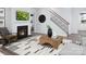 Cozy living room with a fireplace, staircase, and contemporary decor, creating a warm and inviting space at 12305 Gambrell Dr, Charlotte, NC 28278