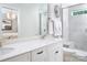 Bright bathroom with double sinks, quartz countertops, white cabinets, and tiled shower with glass door at 12309 Gambrell Dr, Charlotte, NC 28278