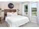 Bright bedroom with a large window, white bedding, decorative accents, and natural light at 12309 Gambrell Dr, Charlotte, NC 28278