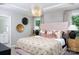 Luxurious bedroom featuring a plush bed, stylish lighting, tray ceilings, and ensuite bathroom access at 12309 Gambrell Dr, Charlotte, NC 28278