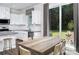 Bright white eat-in kitchen featuring granite countertops and stainless steel appliances adjacent to outdoor patio at 12309 Gambrell Dr, Charlotte, NC 28278