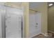 Bright bathroom with a shower-tub combo features a glass door at 12724 Frank Wiley Ln, Charlotte, NC 28278