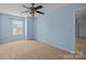 Light blue bedroom with ceiling fan, carpet, and window at 12724 Frank Wiley Ln, Charlotte, NC 28278