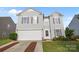 Charming two-story home with gray siding, manicured lawn, and attached two-car garage at 12724 Frank Wiley Ln, Charlotte, NC 28278