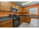 Traditional kitchen features wooden cabinets, black appliances and laminate countertop at 12724 Frank Wiley Ln, Charlotte, NC 28278