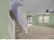 Bright living room features a staircase, neutral carpet, and views of backyard at 12724 Frank Wiley Ln, Charlotte, NC 28278