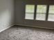 This bedroom features carpet and natural light from the three windows with blinds at 13123 Ashley Meadow Dr, Charlotte, NC 28213
