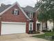 A two-story brick home with an attached two-car garage and meticulously maintained lawn and landscaping at 13123 Ashley Meadow Dr, Charlotte, NC 28213