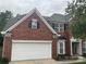 A two-story brick home with an attached two-car garage and meticulously maintained lawn and landscaping at 13123 Ashley Meadow Dr, Charlotte, NC 28213