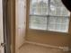 This hallway features tile flooring, a door and natural light from the window with blinds at 13123 Ashley Meadow Dr, Charlotte, NC 28213