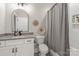 Bathroom features a white vanity, a toilet, a shower/tub combo, and a gray shower curtain at 1445 Cherry Laurel Dr, Waxhaw, NC 28173