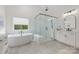 Bright bathroom featuring a walk-in shower, soaking tub, and double vanity with white cabinets and neutral countertops at 1445 Cherry Laurel Dr, Waxhaw, NC 28173