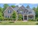 Beautiful two-story home with a brick exterior, professionally landscaped yard, and inviting front porch at 1445 Cherry Laurel Dr, Waxhaw, NC 28173