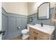 Stylish powder room featuring elegant wall paneling and a wood vanity with black hardware at 1445 Cherry Laurel Dr, Waxhaw, NC 28173