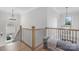 Spacious upstairs landing with wooden railing, modern chandelier and abundant natural light at 1445 Cherry Laurel Dr, Waxhaw, NC 28173