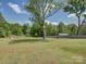 Expansive backyard featuring a shed, mature trees, lush lawn, providing a serene retreat and ample space at 1454 King Rd, York, SC 29745