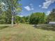 The spacious backyard boasts a beautiful lawn, a shed, and mature trees, great potential for relaxation and activities at 1454 King Rd, York, SC 29745