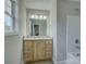 Bathroom vanity with light wood cabinets, granite countertop, framed mirror and natural light at 1454 King Rd, York, SC 29745