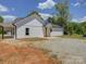 New construction white home with a gravel driveway, shed and grass yard at 1454 King Rd, York, SC 29745