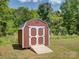 A well-maintained red shed with white trim and doors, offering extra storage and potential for workshop at 1454 King Rd, York, SC 29745