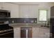 Kitchen with stainless steel appliances, mosaic backsplash, white cabinets, and granite countertops at 14621 Waterside Dr, Charlotte, NC 28278