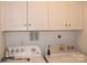 Laundry room featuring a washer and dryer with overhead storage cabinets and white walls at 14621 Waterside Dr, Charlotte, NC 28278