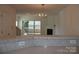 Living room showcasing fireplace, light fixture, access to balcony and open floor plan at 14621 Waterside Dr, Charlotte, NC 28278