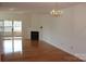Bright living room with hardwood floors, fireplace, chandelier, and balcony access at 14621 Waterside Dr, Charlotte, NC 28278