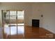 Living room boasting hardwood floors, sliding door access to balcony, and cozy fireplace at 14621 Waterside Dr, Charlotte, NC 28278